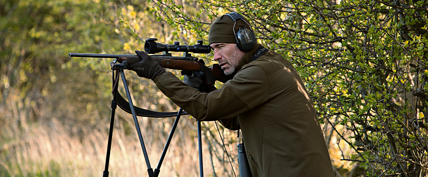 Jäger, der im Frühling mit Schießstock schießt
